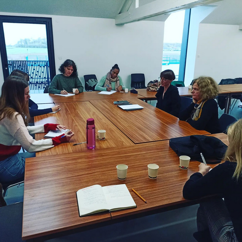 Photo en salle de réunion avec Émilie BOUGOUIN expliquant les points essentiels de la formation, debout, face aux participantes.